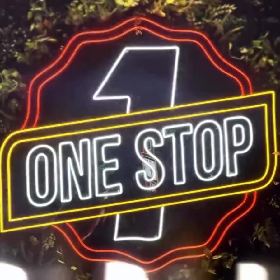Letreiro de neon do One Stop sobre parede de plantas