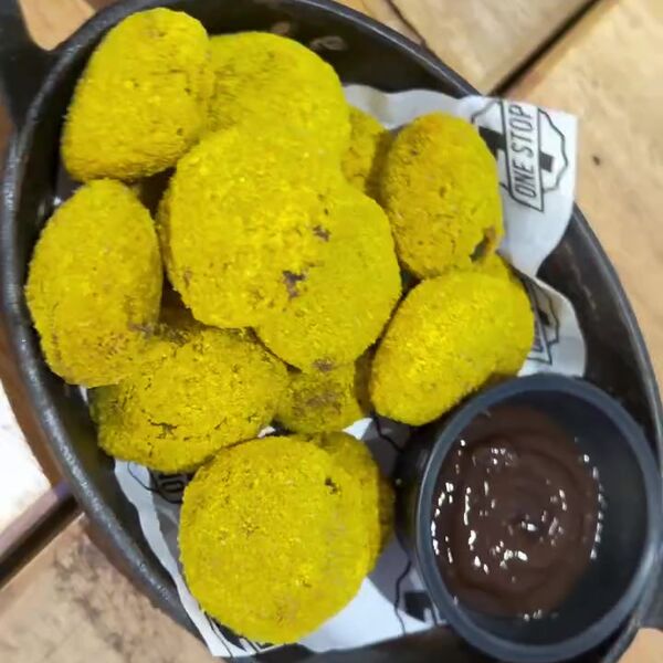Bolinhos empanados servidos na panelinha de ferro